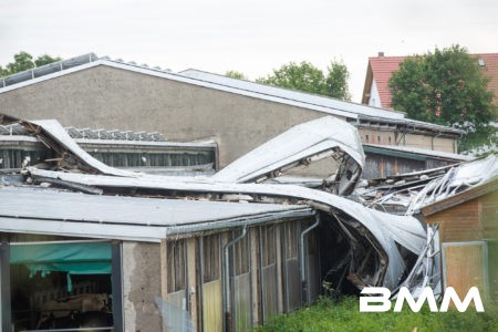 Groß-Krauscha In Groß-Krauscha kam es in der Nacht zu einem heftigen Unwetterschaden. Durch massiven Sturm, Hagel und Regen wurde hier eine Photovoltaikanlage eines Kuhstalls auf einer Fläche von 20x50 Metern komplett abgedeckt und auf anderen benachbarten Ställen, dem Melkhaus und dem Vorplatz verteilt. Stromkabel hingen in den Stall hinein, sodass eine Gefahr für Mensch und die rund 350 Tiere der Anlage bestand. In einer nächtlichen Aktion mit Feuerwehr und THW wurde eine provisorische Koppel mit Strohballen errichtet und die Tiere dahin evakuiert. Im weiteren Tagesverlauf bauten die Mitglieder der Feuerwehr und des THW Görlitz auf einem benachbarten Feld eine provisorische weitere Koppel, indem bei Platzmangel ausgewichen werden kann. Aktuell ist noch unklar, ob der Melkbetrieb weiter gehen kann oder ob die Tiere mit einem noch nicht organisierten fahrbaren Melkstand in der Freiheit gemolken werden muss. Aktuell laufen die Arbeiten noch.